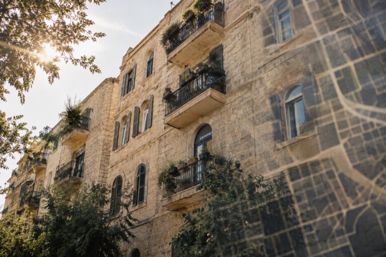 חזית בניין מגורים ותיק עם מרפסות ועצים