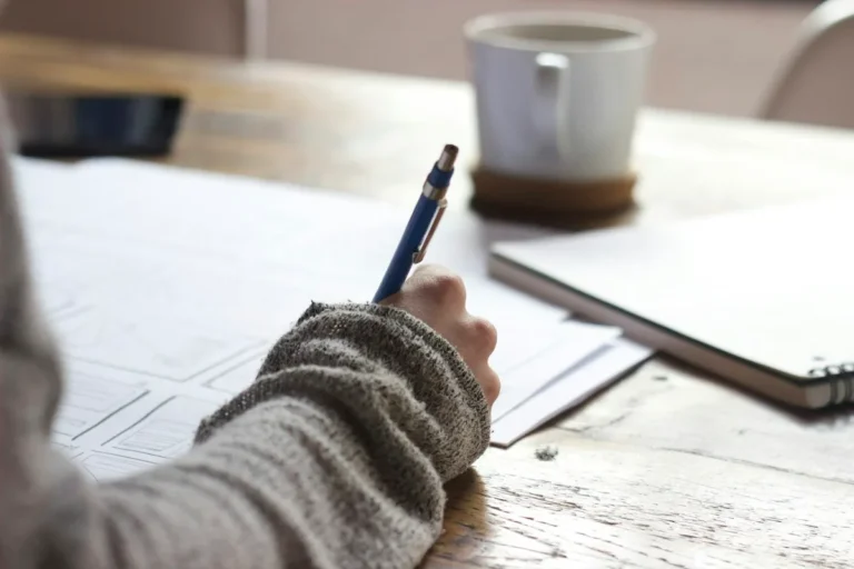 Écriture dans un carnet près d’une tasse – délai d’enregistrement d’une marque